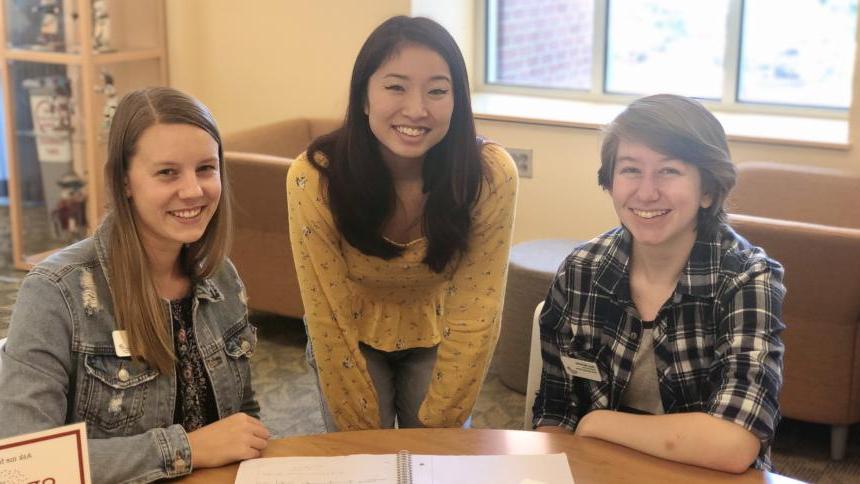 Three tutors smiling facing the camera