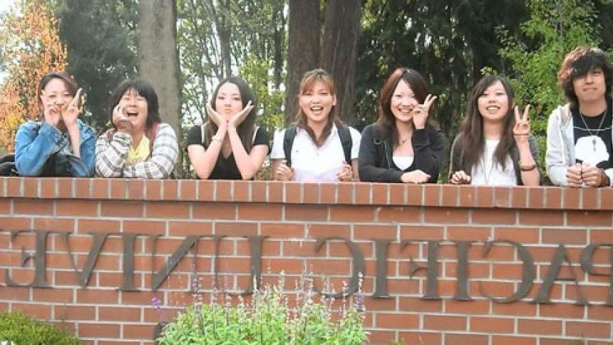 International Students pose in front of Pacific University sign